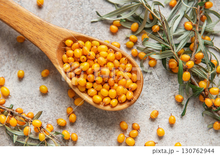 Wooden spoon overflowing with fresh sea buckthorn berries and leaves Wooden spoon overflowing with fresh sea buckthorn berries and leaves 130762944