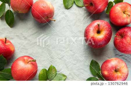 Fresh red apples forming a border on gray linen cloth Fresh red apples forming a border on gray linen cloth 130762946