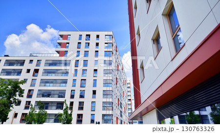 Exterior of a high modern multi-story apartment building - facade, windows and balconies. Timeless glass facade. Modern urban living district. 130763326
