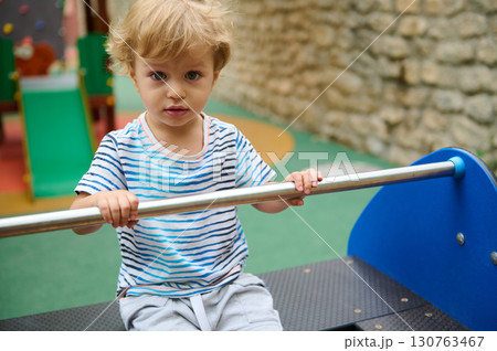 Child Enjoying Outdoors Playground Activities on a Fun Sunny Day 130763467