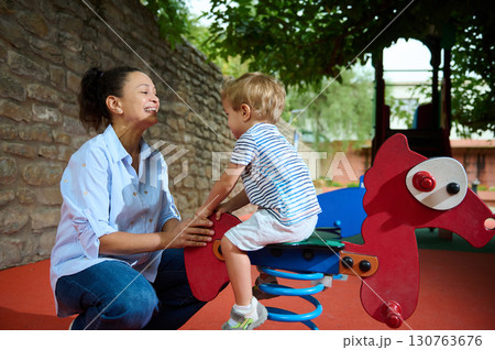 Mother and Child Enjoying Playtime at the Playground Together Mother and Child Enjoying Playtime at the Playground Together 130763676