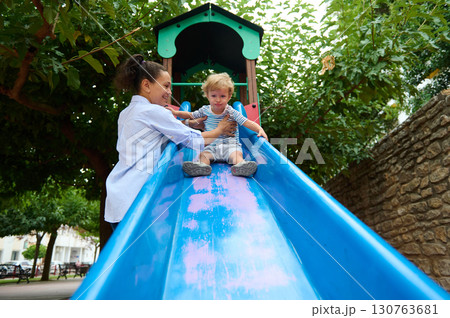 Mother and Child Enjoying Time Together at Playground Slide 130763681