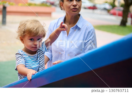 Child and Guardian Interacting at a Colorful Playground 130763711