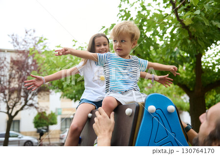 Happy Children Enjoying Outdoor Playtime in a Lush Green Park Area 130764170