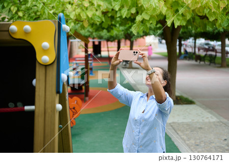 Woman Taking a Picture in a Vibrant Urban Playground 130764171