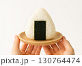白ごはんの三角おにぎりとナチュラルな手元 130764474