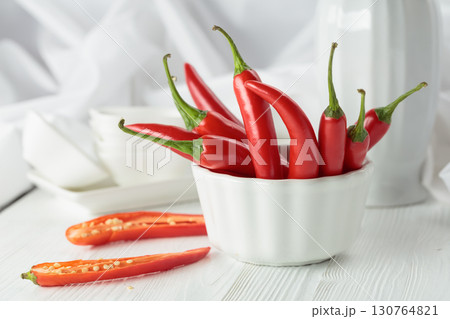 Fresh red chili peppers with on a white wooden table. Fresh red chili peppers with on a white wooden table. 130764821