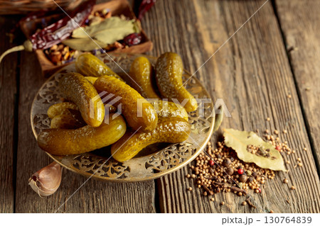 Pickled cucumbers with ingredients on an old wooden table. Pickled cucumbers with ingredients on an old wooden table. 130764839