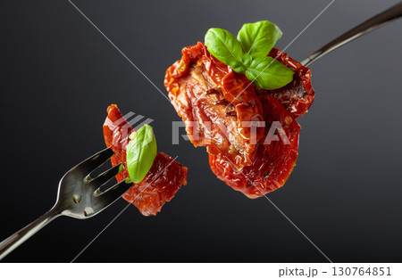 Sun dried tomatoes in olive oil with green basil. 130764851