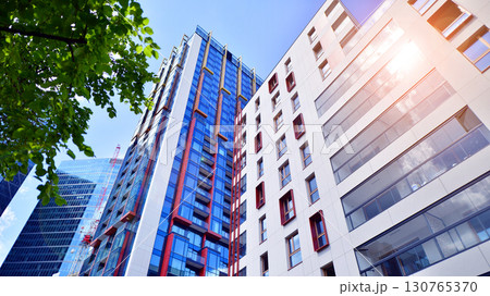 European residential architecture harmonizing with nature. Eco-friendly living in city with greens. Eco apartment building saving energy and fresh air concept.  130765370