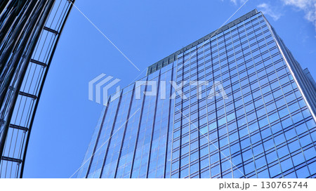 Modern sustainable glass office buildings. Exterior view of corporate headquarters glass buildings architecture.Glass windows in energy-efficient buildings. Financial business center buildings.  130765744