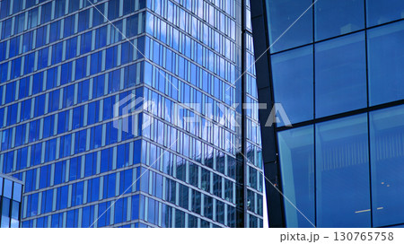 Modern sustainable glass office buildings. Exterior view of corporate headquarters glass buildings architecture.Glass windows in energy-efficient buildings. Financial business center buildings.  130765758