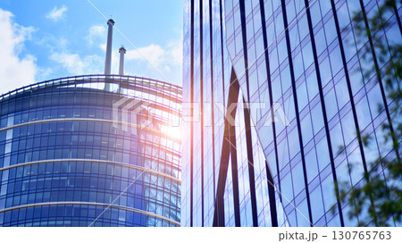 Modern sustainable glass office buildings. Exterior view of corporate headquarters glass buildings architecture.Glass windows in energy-efficient buildings. Financial business center buildings.  130765763