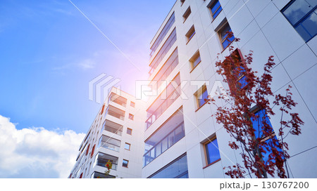 View of an modern apartment building standing next to a new modern office building with a glass facade. 130767200