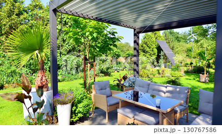 Modern aluminum pergola with stylish garden furniture in a beautiful garden. Modern aluminum pergola with stylish garden furniture in a beautiful garden. 130767586