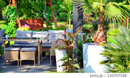 Modern aluminum pergola with stylish garden furniture in a beautiful garden. 130767598