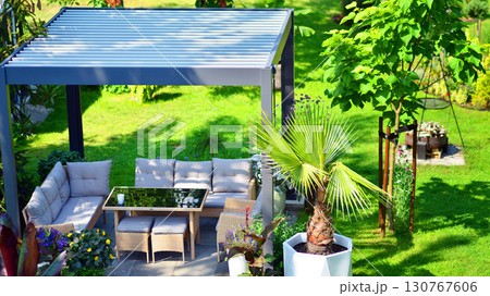 Modern aluminum pergola with stylish garden furniture in a beautiful garden. Modern aluminum pergola with stylish garden furniture in a beautiful garden. 130767606