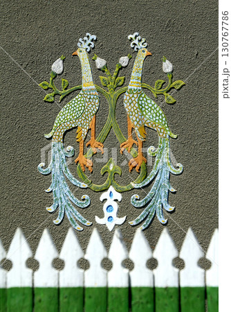 Two colorful peacocks painting on a rough wall with wooden fence Two colorful peacocks painting on a rough wall with wooden fence 130767786