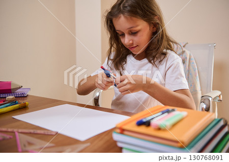 Young Girl Engaged in Creative Art Projects at a Well-Organized Home Desk Young Girl Engaged in Creative Art Projects at a Well-Organized Home Desk 130768091