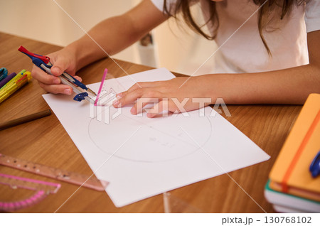 Young Student Using Geometry Tools for Circle Drawing on a Wooden Desk Young Student Using Geometry Tools for Circle Drawing on a Wooden Desk 130768102