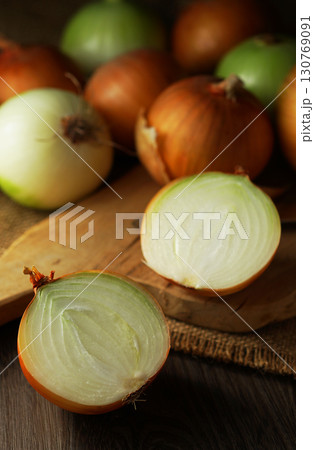 半分にカットされた玉ねぎとたくさんの玉ネギ 半分にカットされた玉ねぎとたくさんの玉ネギ 130769091