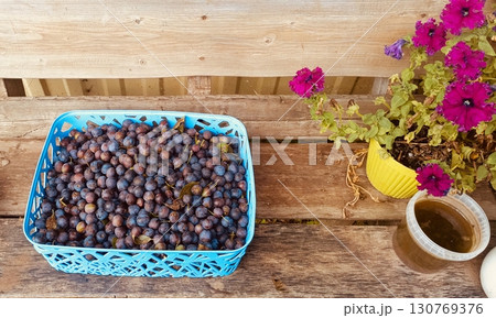 Harvested sloes and petunias in a rustic still life in blue, purple, and yellow hues representing autumn and homemade preserves Harvested sloes and petunias in a rustic still life in blue, purple, and yellow hues representing autumn and homemade preserves 130769376