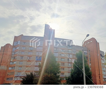 Orange brick apartment building in an optimistic style in bright sunlight representing urban living Orange brick apartment building in an optimistic style in bright sunlight representing urban living 130769388