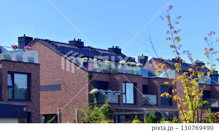 Harmony with nature, eco architecture. Terraced single family homes in newly developed housing estate. The real estate market in the suburbs with lush greenery surrounding.  130769490