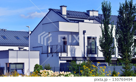 Harmony with nature, eco architecture. Terraced single family homes in newly developed housing estate. The real estate market in the suburbs with lush greenery surrounding.  130769494