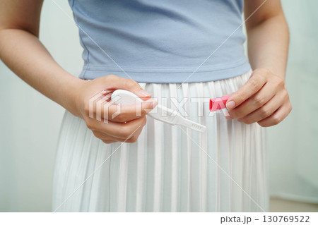 Asian holding pregnancy test for female of ovulation day, fetus, maternity, childbirth, birth control. 130769522