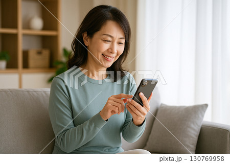 スマホを見る中年女性 130769958
