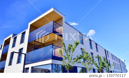 European residential architecture harmonizing with nature. Eco-friendly living in city with greens. Eco apartment building saving energy and fresh air concept.  European residential architecture harmonizing with nature. Eco-friendly living in city with greens. Eco apartment building saving energy and fresh air concept.  130770117