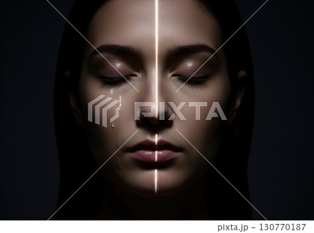 Conceptual portrait of a crying woman with a light beam scanning her sad face 130770187