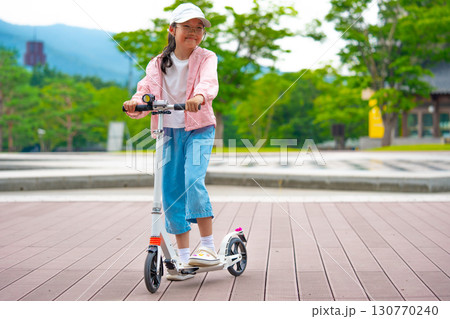 Asian girl is going to ride a scooter. Copy space 130770240