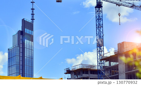 Modern office building with glass facade. Transparent glass wall of office building. Reflection of the blue sky on the facade of the building. 130770932