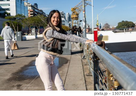 Young woman leaning on a bridge railing enjoying the view of puerto madero 130771437