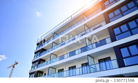 Modern apartment buildings on a sunny day with a blue sky. Facade of a modern apartment building. Modern residential apartment building complex condo. Modern apartment buildings on a sunny day with a blue sky. Facade of a modern apartment building. Modern residential apartment building complex condo. 130771506