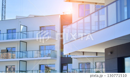 Modern apartment buildings on a sunny day with a blue sky. Facade of a modern apartment building. Modern residential apartment building complex condo. 130771510