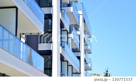 Modern apartment buildings on a sunny day with a blue sky. Facade of a modern apartment building. Modern residential apartment building complex condo. 130771537