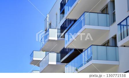 Modern apartment buildings on a sunny day with a blue sky. Facade of a modern apartment building. Modern residential apartment building complex condo. Modern apartment buildings on a sunny day with a blue sky. Facade of a modern apartment building. Modern residential apartment building complex condo. 130771538
