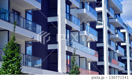 Modern apartment buildings on a sunny day with a blue sky. Facade of a modern apartment building. Modern residential apartment building complex condo. Modern apartment buildings on a sunny day with a blue sky. Facade of a modern apartment building. Modern residential apartment building complex condo. 130771541