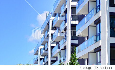 Modern apartment buildings on a sunny day with a blue sky. Facade of a modern apartment building. Modern residential apartment building complex condo. 130771544