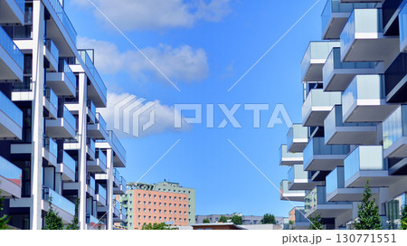 Modern apartment buildings on a sunny day with a blue sky. Facade of a modern apartment building. Modern residential apartment building complex condo. Modern apartment buildings on a sunny day with a blue sky. Facade of a modern apartment building. Modern residential apartment building complex condo. 130771551