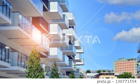 Modern apartment buildings on a sunny day with a blue sky. Facade of a modern apartment building. Modern residential apartment building complex condo. 130771554
