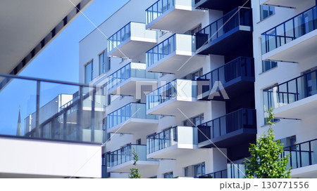 Modern apartment buildings on a sunny day with a blue sky. Facade of a modern apartment building. Modern residential apartment building complex condo. 130771556