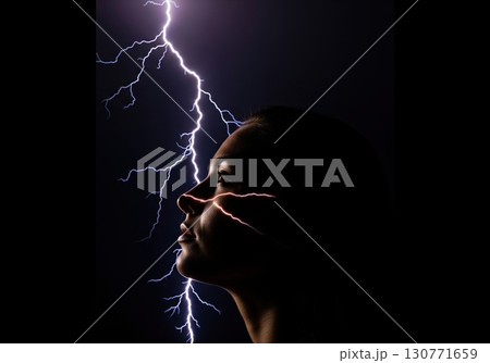 Conceptual portrait of a woman's silhouette with a lightning bolt striking through her 130771659