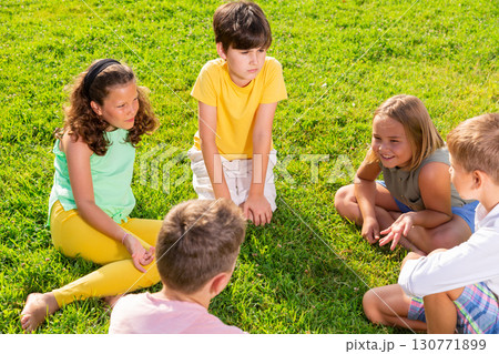 Group of kids sitting on grass Group of kids sitting on grass 130771899