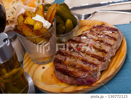 Appetizing beef entrecote with boiled potatoes and pickled cucumbers Appetizing beef entrecote with boiled potatoes and pickled cucumbers 130772125