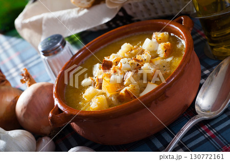 Vegetable soup with croutons and cheese in a clay plate 130772161