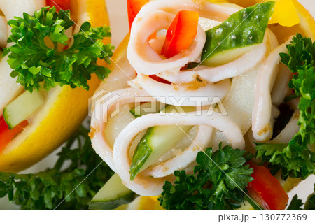Tropical salad with squids served in lemon with cucumbers and pepper 130772369
